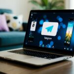 Um laptop aberto em uma mesa de café, com o aplicativo Telegram aberto e um filme sendo reproduzido na tela